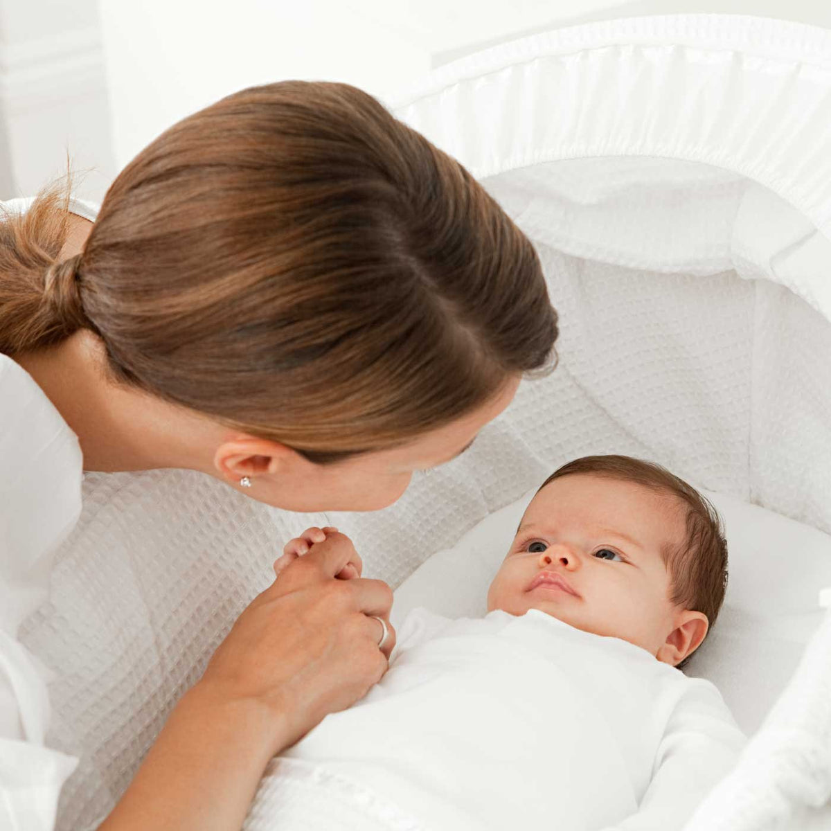 A mother smiling at her newborn